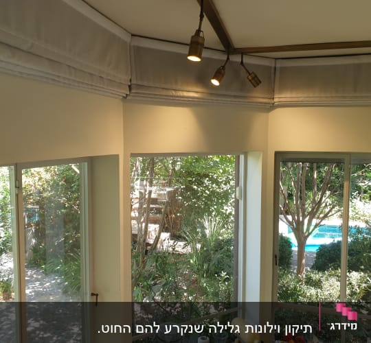 וילון לבן מקופל בחלק העליון של החלון